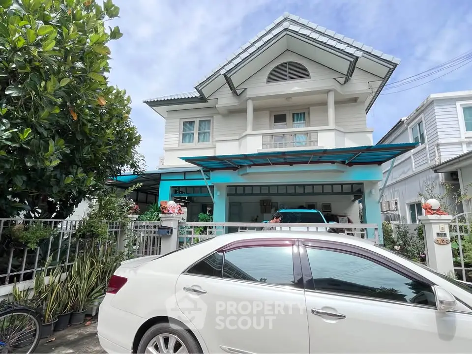 Charming two-story house with a modern design, featuring a spacious driveway and lush greenery, perfect for family living.