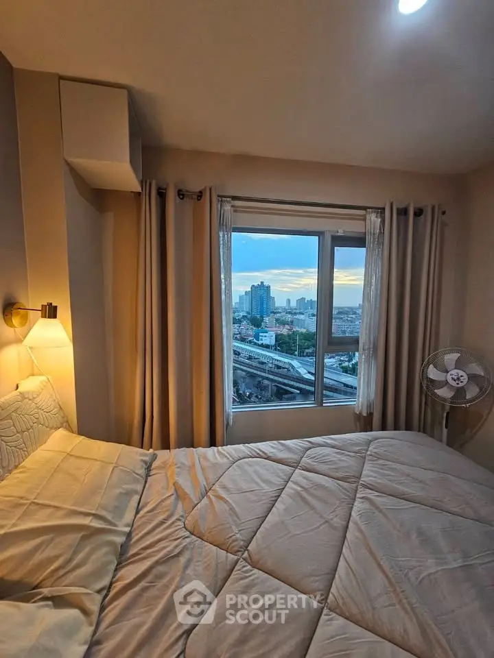 Cozy bedroom with city view, featuring a large window and elegant lighting, perfect for urban living.