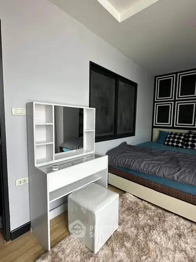 Modern bedroom with stylish decor and cozy furnishings, featuring a sleek vanity and plush rug.