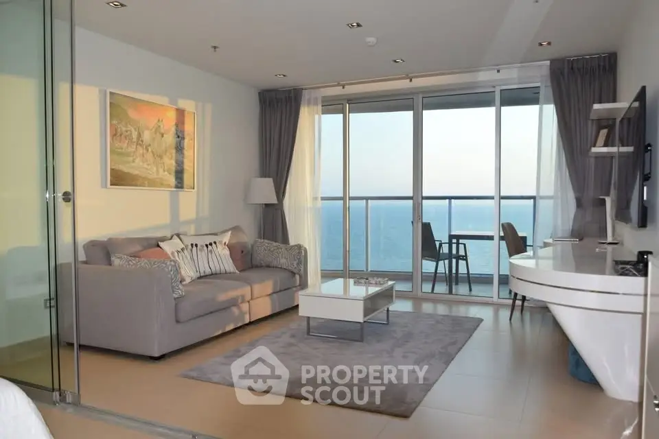 Luxurious living room with ocean view, modern furniture, and elegant decor in a high-rise apartment.