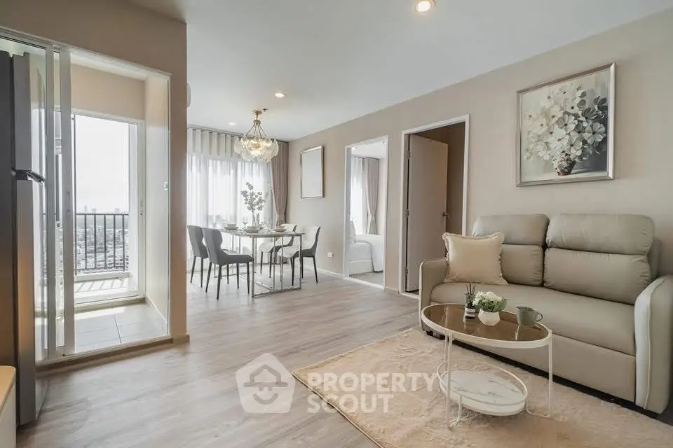 Modern living room with elegant decor and open dining area, featuring a balcony with a stunning view.