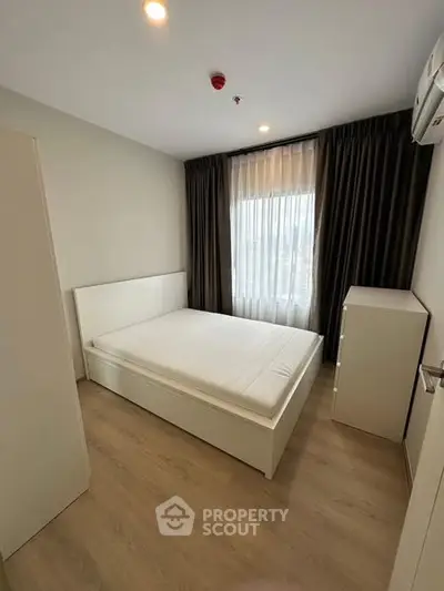 Modern minimalist bedroom with natural light and sleek furnishings.