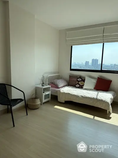 Bright bedroom with city view, cozy bed, and modern decor in urban apartment.