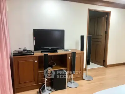 Cozy living room with wooden TV stand and modern sound system, perfect for entertainment.