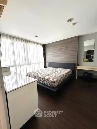 Spacious bedroom with modern decor and large windows for natural light