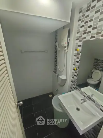 Modern bathroom with sleek tiles and contemporary fixtures in a stylish apartment.