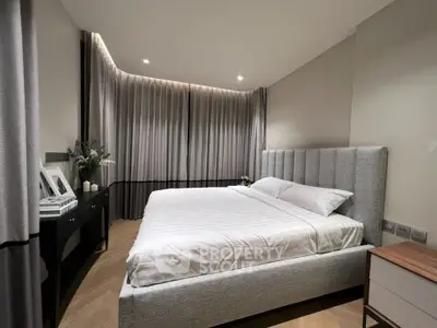 Luxurious bedroom with elegant decor and plush bedding in modern apartment.