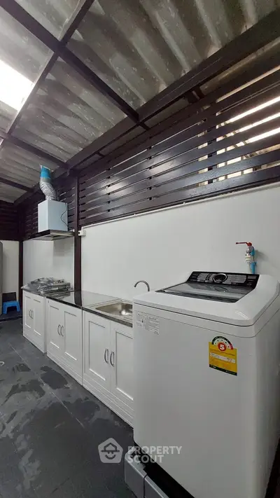Modern kitchen with washing machine and gas stove in open layout