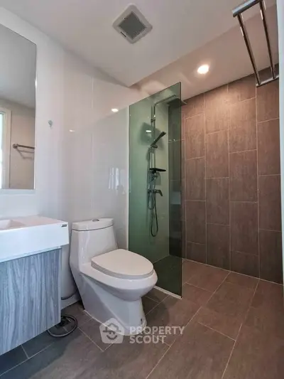 Modern bathroom with glass shower and sleek fixtures in contemporary apartment.