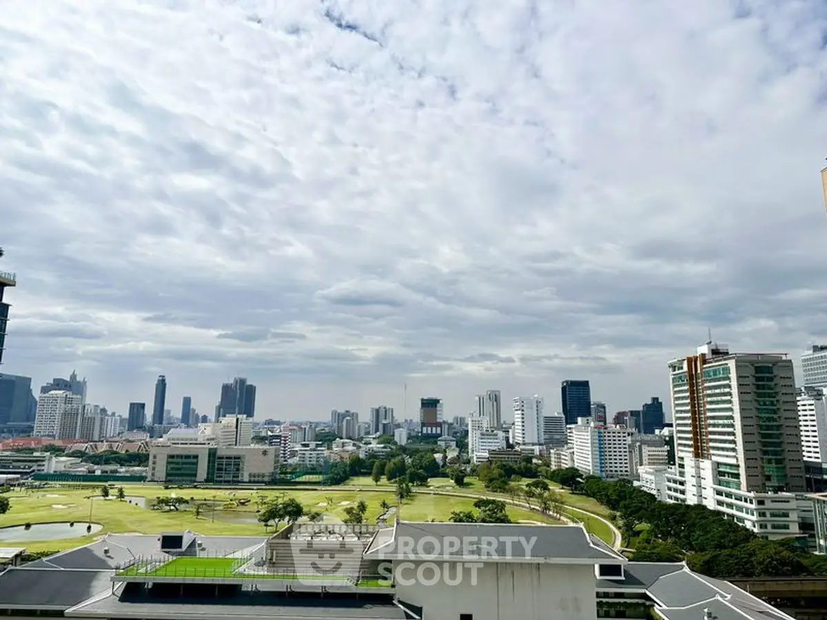 Stunning cityscape view from a high-rise building showcasing urban skyline and greenery.