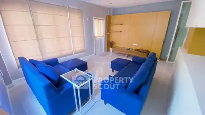 Modern living room with blue sofas and stylish decor, perfect for relaxation and entertainment.