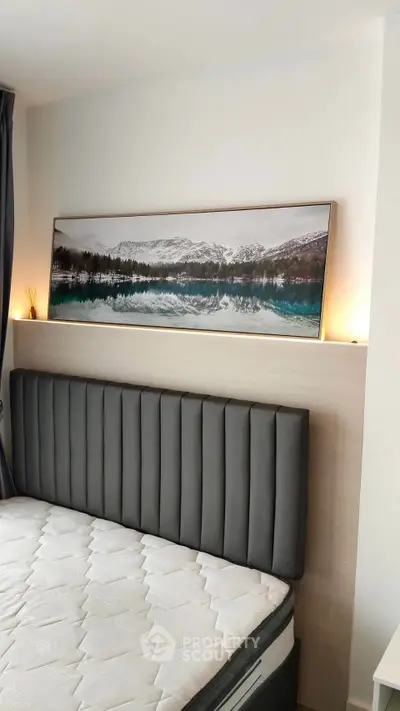 Modern bedroom with stylish headboard and scenic artwork, perfect for relaxation and comfort.