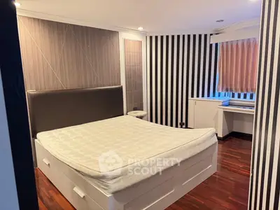 Modern bedroom with stylish striped wallpaper and wooden flooring