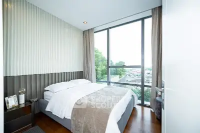 Modern bedroom with large windows offering stunning city views and elegant decor.