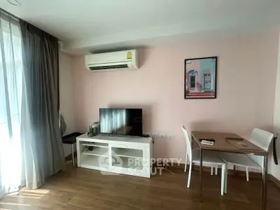 Charming living room with modern decor, featuring a wall-mounted air conditioner and stylish furniture.