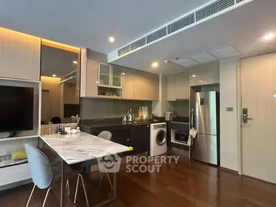 Modern kitchen with sleek appliances and marble dining table in open layout