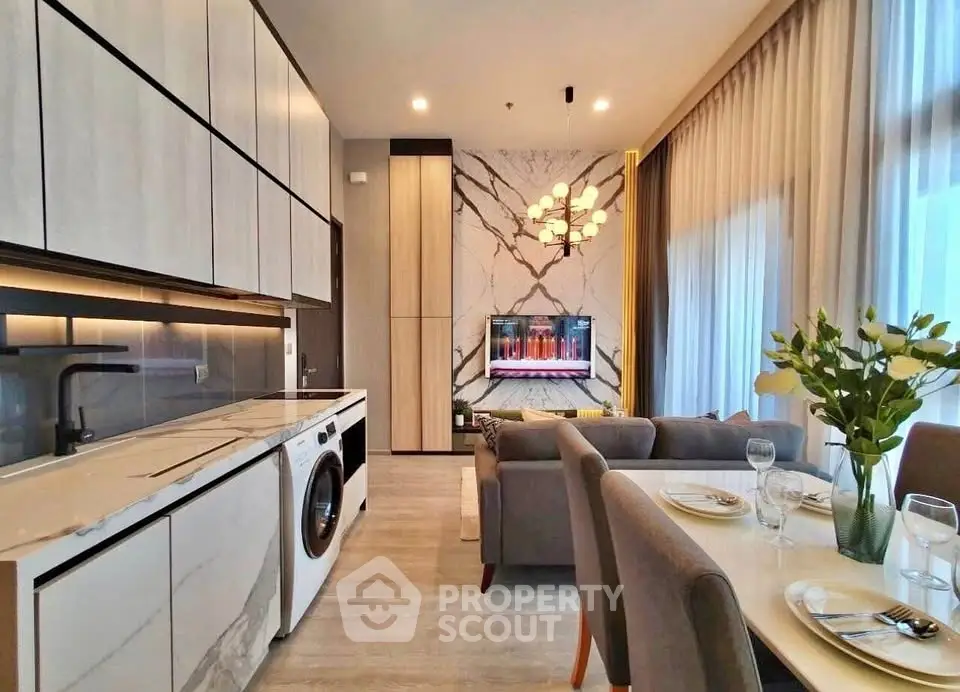 Modern open-plan kitchen and living room with elegant decor and natural light.