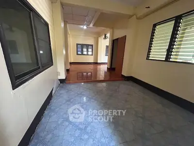 Spacious interior with tiled floors and large windows, perfect for versatile living space.