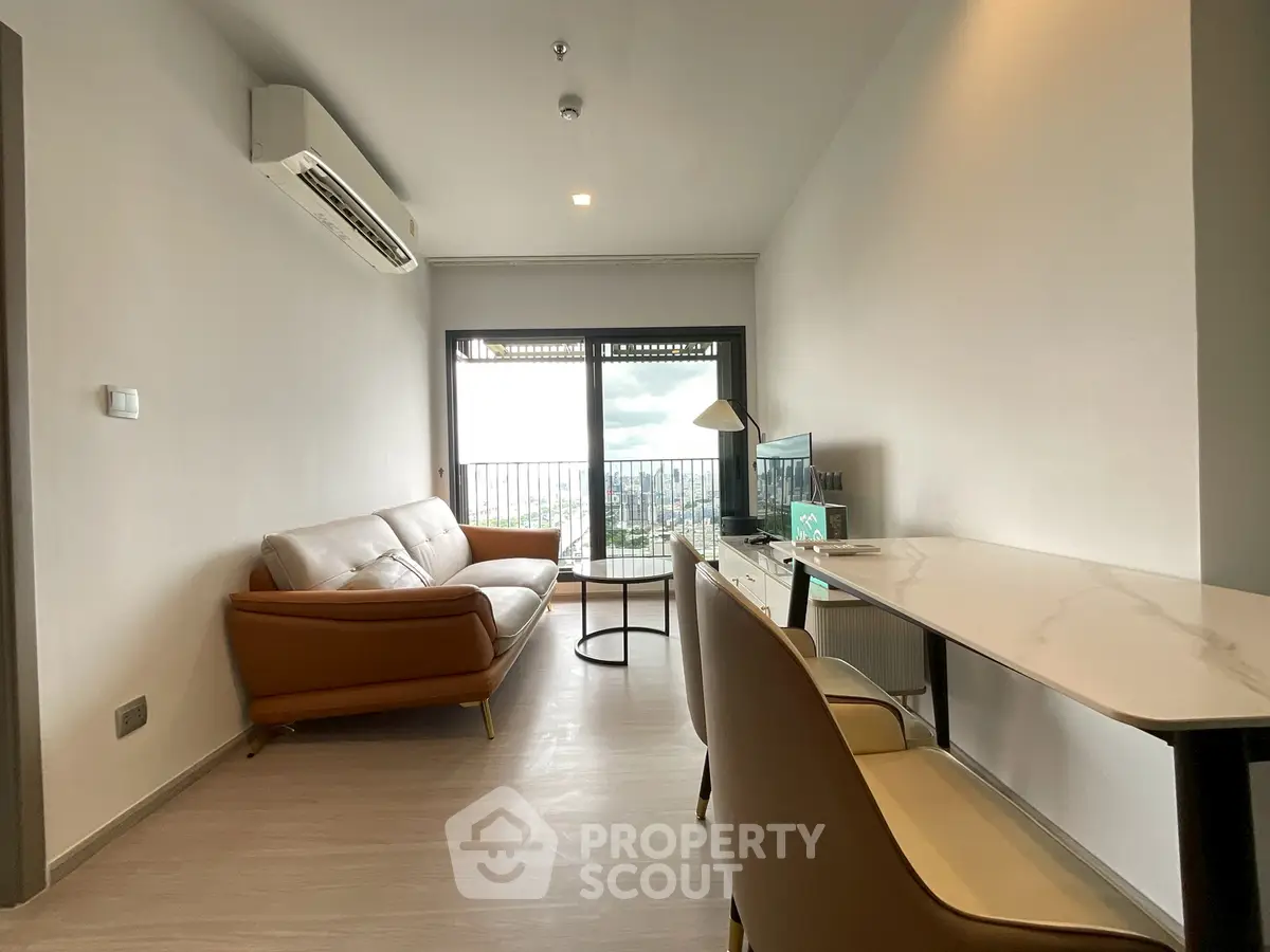 Modern living room with city view, stylish furniture, and natural light.