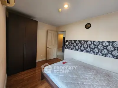 Spacious bedroom with modern decor and wooden flooring