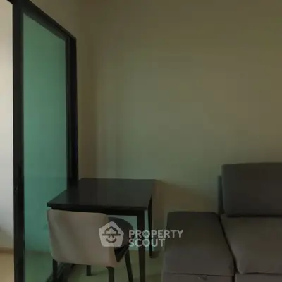 Cozy living room with modern sofa and compact dining area, perfect for urban living.