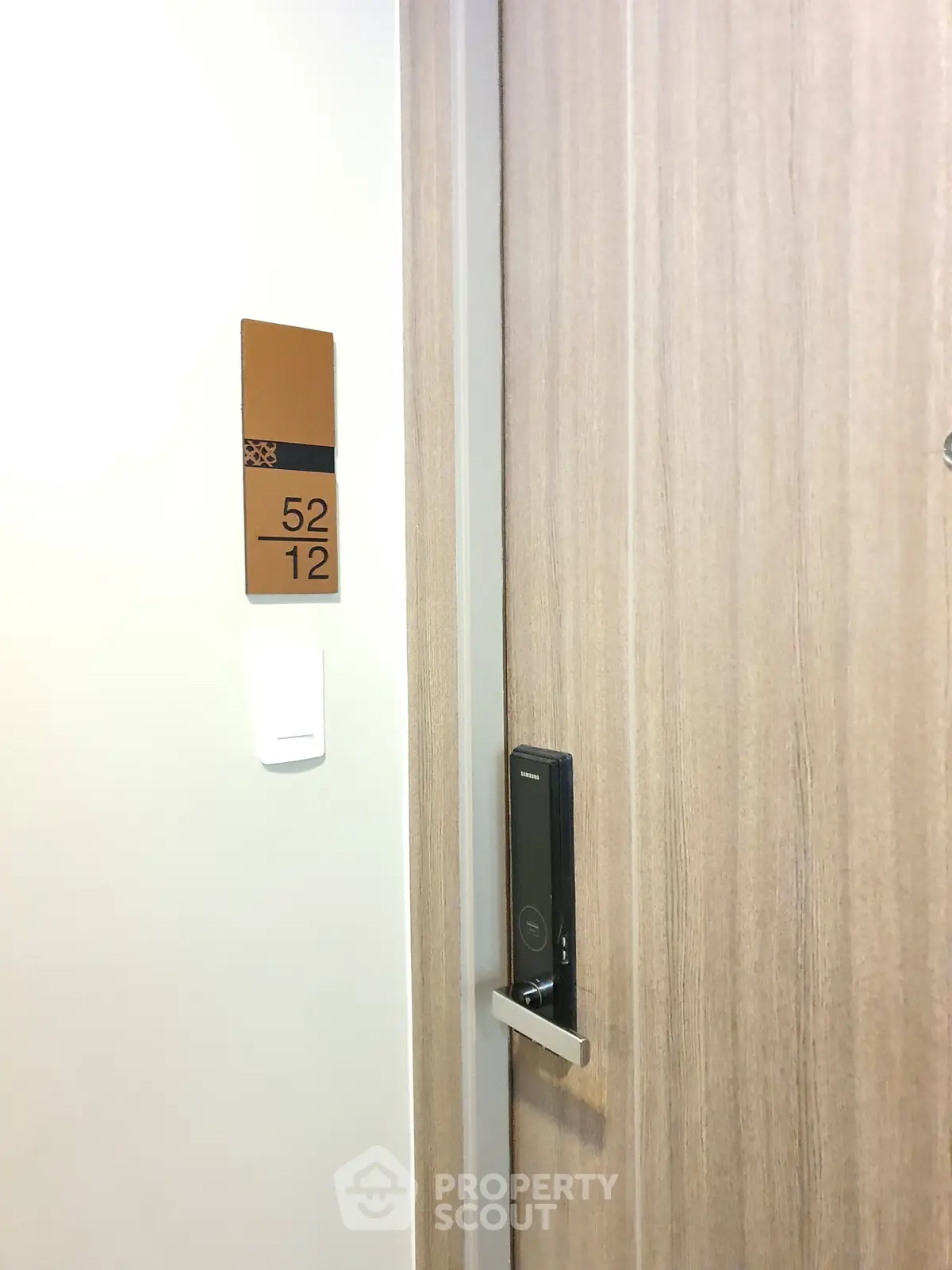 Modern apartment door with electronic lock and room number 5212, showcasing secure entry features.
