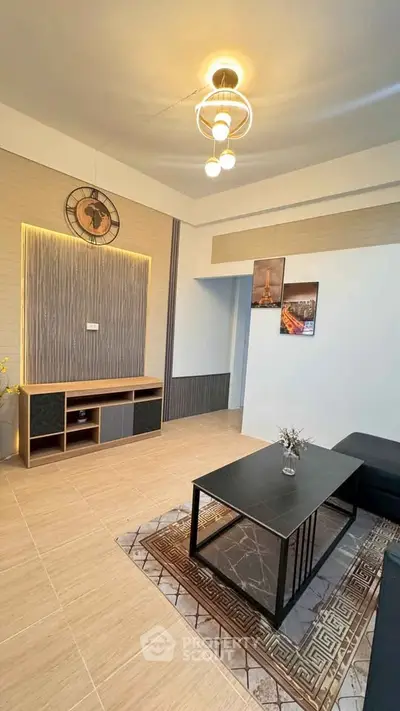 Modern living room with stylish decor and elegant lighting, featuring a sleek coffee table and wall art.
