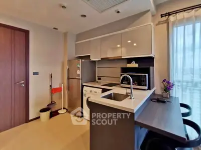 Modern kitchen with sleek cabinetry, integrated appliances, and cozy dining area.