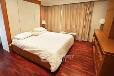 Spacious bedroom with elegant wooden flooring and cozy ambiance