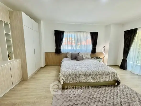 Spacious modern bedroom with large windows and elegant decor