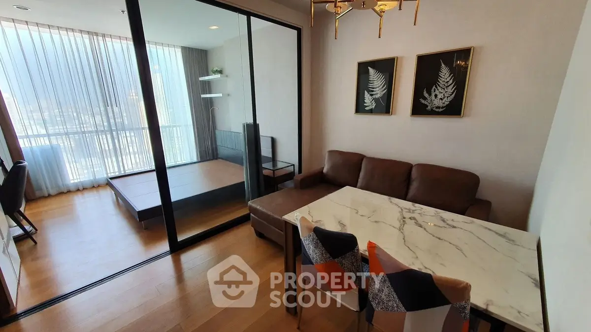 Modern living room with glass partition and stylish decor in a high-rise apartment.