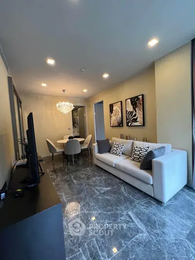 Elegant living room with marble flooring, modern decor, and a stylish dining area in a luxury apartment.