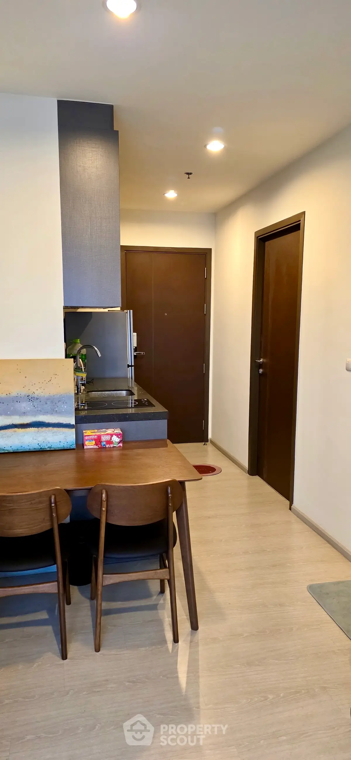 Modern apartment entrance with sleek kitchen and dining area