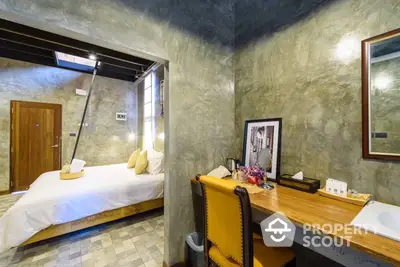 Chic industrial-style bedroom with polished concrete walls, a cozy bed, and a stylish work area, perfect for modern living.