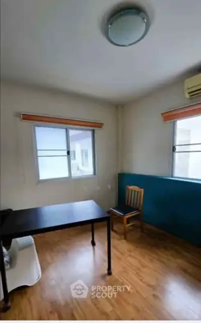 Spacious study room with wooden flooring and ample natural light