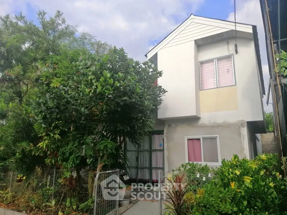 Charming two-story house with lush garden and modern facade, perfect for family living.