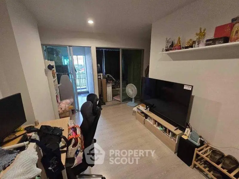 Modern living room with sleek TV setup and balcony view, perfect for urban living.