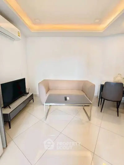 Modern living room with sleek furniture and minimalist design, featuring a cozy sofa and flat-screen TV.