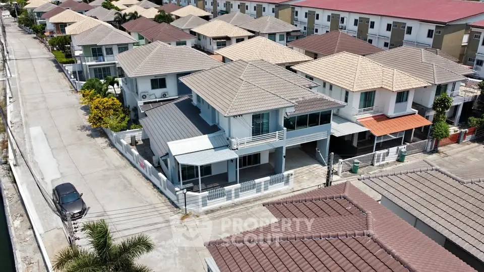Aerial view of modern suburban houses with tiled roofs and spacious driveways in a well-planned neighborhood.