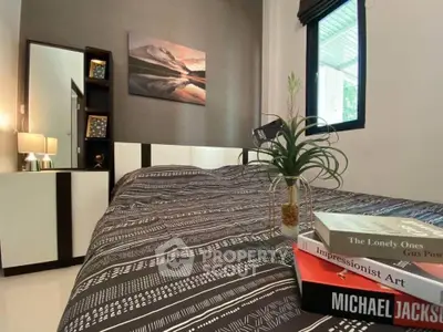 Cozy bedroom with modern decor and stylish bedding, featuring a window view and elegant furnishings.
