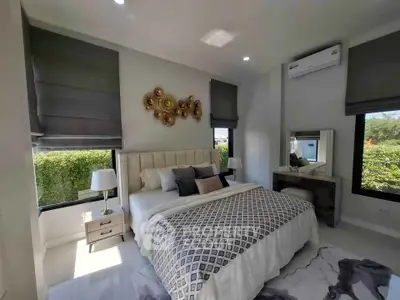 Luxurious bedroom with elegant decor and large windows offering garden views, perfect for relaxation.