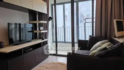 Modern living room with cozy sofa, TV, and balcony access in stylish apartment.