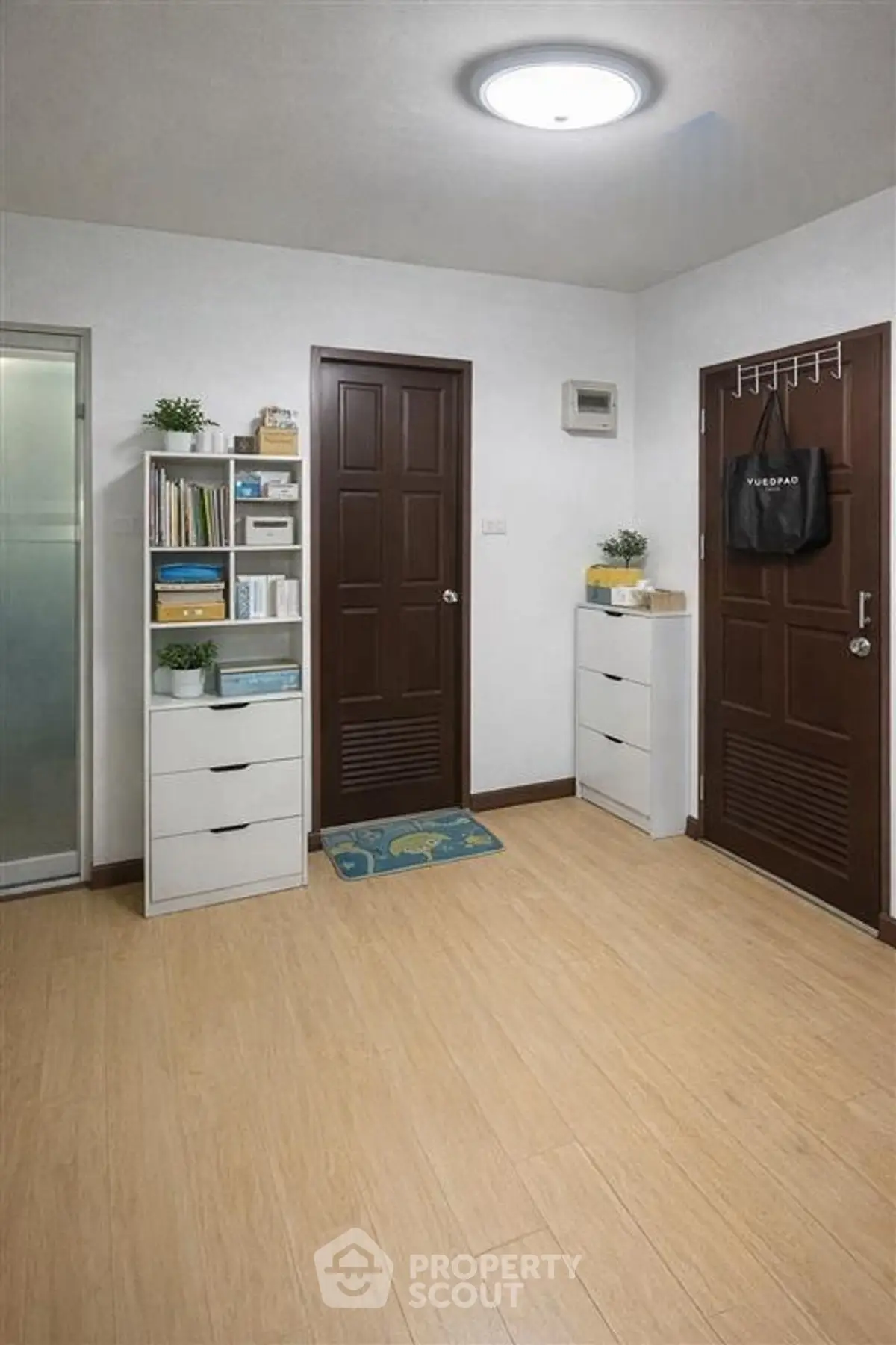 Charming entryway with wooden doors and modern storage solutions in a cozy apartment.