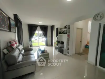 Spacious modern living room with sleek furniture and large windows offering natural light.