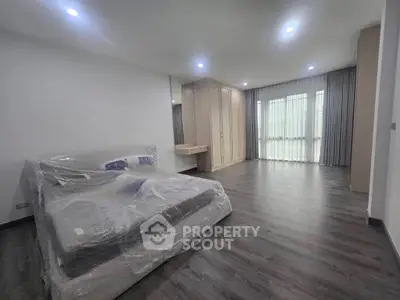 Spacious bedroom with modern design and large windows for natural light.