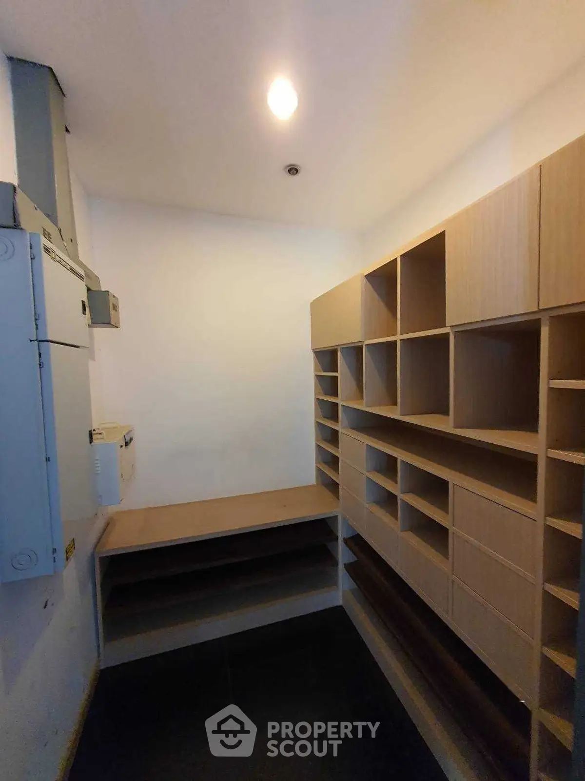 Spacious storage room with built-in wooden shelves and ample lighting
