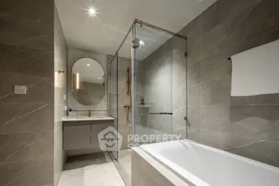 Luxurious modern bathroom with elegant gray tiles and glass shower enclosure.
