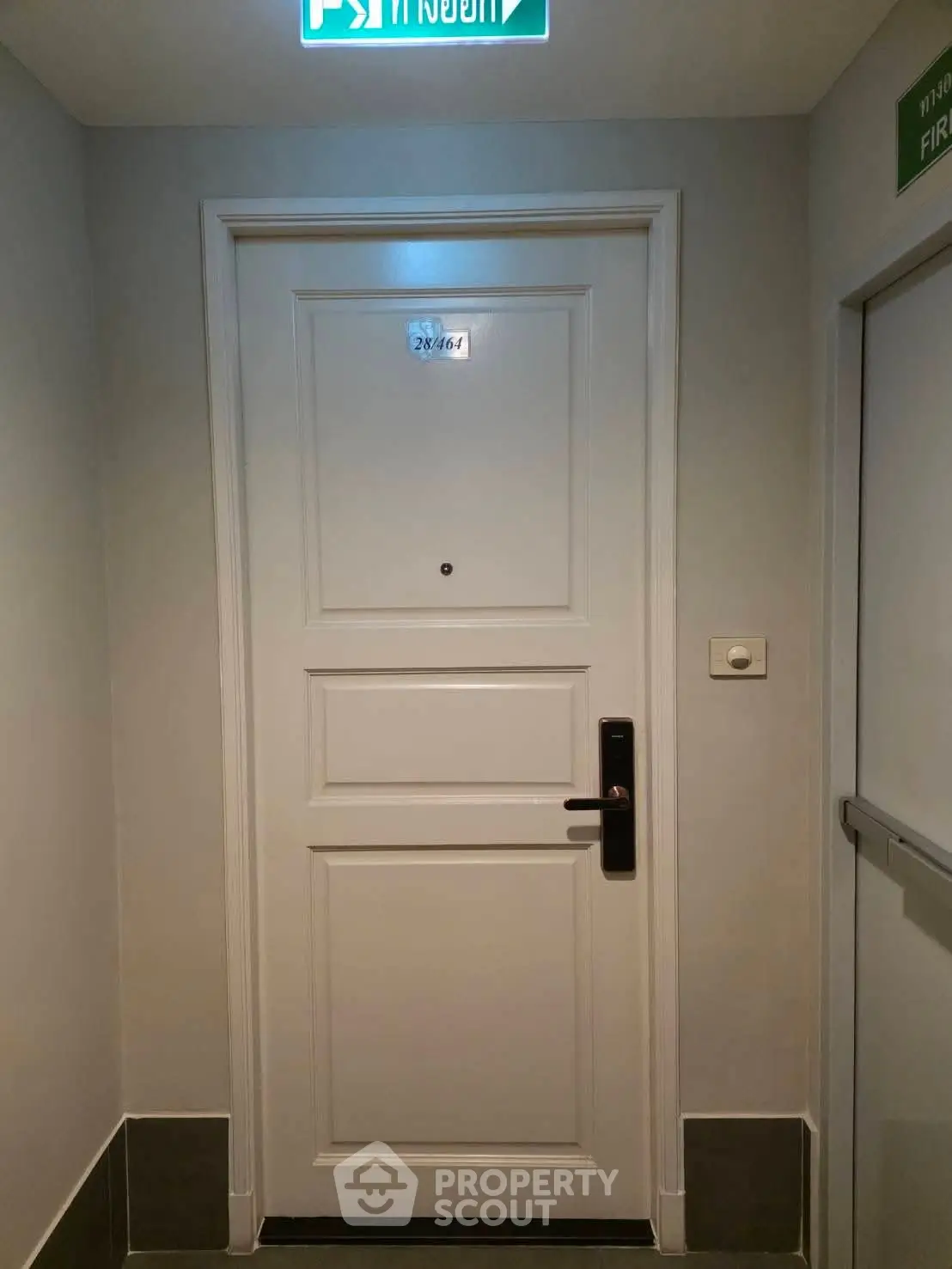 Modern apartment entrance with sleek white door and electronic lock
