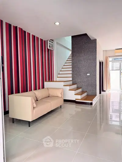 Modern living room with stylish staircase and striped accent wall