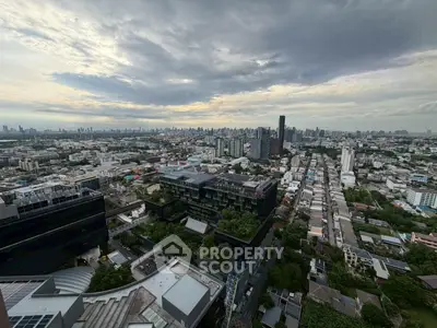 Stunning cityscape view from a high-rise building showcasing urban skyline and lush greenery.
